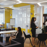 A modern open coworking space with professionals working and collaborating in a bright, well-designed office environment, showcasing an affordable office space for rent with shared desks and meeting areas.